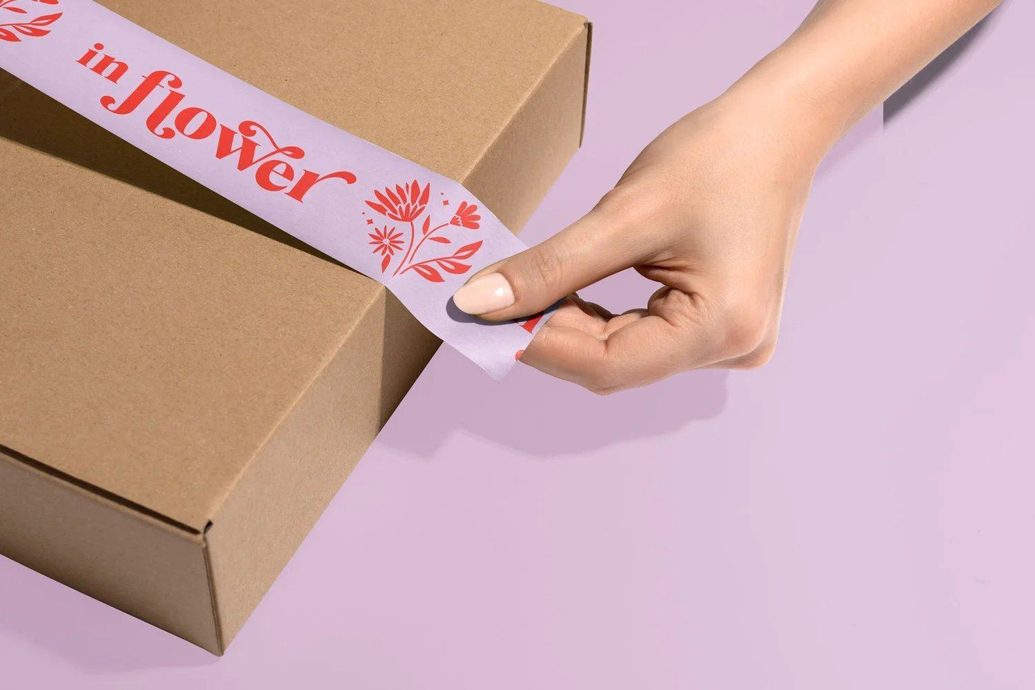 In Flower branded packing tape on a kraft box